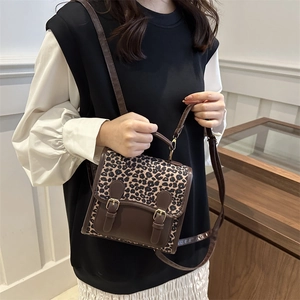 Mini sac bandoulière vintage motif léopard avec lanières en cuir porté par un mannequin