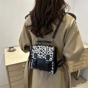 Chic black and white leopard print backpack with faux leather trim and flap closure design