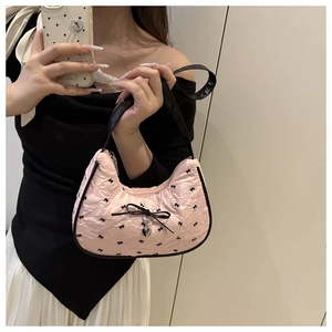 Pink pleated hobo bag with black bow prints and a silver heart pendant detail