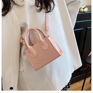Dettaglio della borsa rosa a tracolla intrecciata con trama e ganci in metallo oro