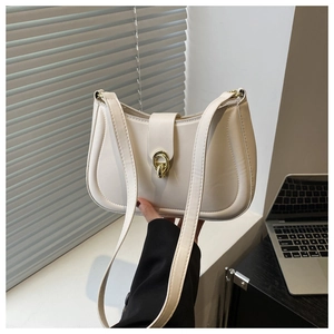 Detailed view of cream-colored shoulder bag with gold circular ring buckle and PU leather finish