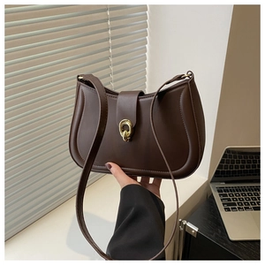 Close-up of dark brown leather handbag with vintage gold buckle and fine stitching