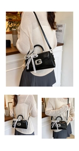 Chic black glossy handbag with a metallic G logo, pearl charms, and lace bow details