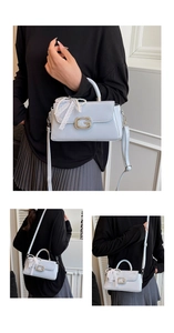 Detail of light blue square crossbody bag with G buckle, lace bow and pearl chain