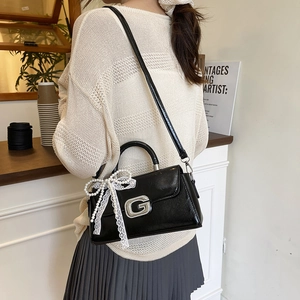 Chic black patent leather crossbody bag with silver G-buckle and pearl lace bow