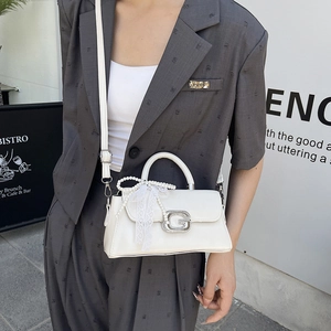 Detail showing the white PU leather bag with crystal G buckle and pearl bow handle