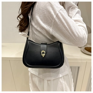 Detail of a black leather hobo bag featuring a signature gold buckle and stitching