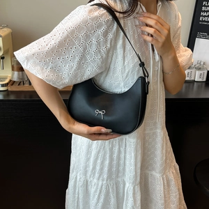 Elegant black crescent hobo bag with a silver bow accent and adjustable shoulder strap