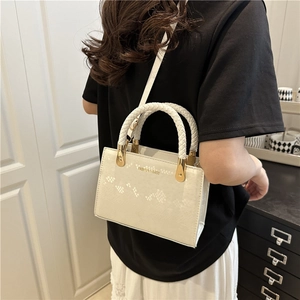 Minimalist white square handbag with braided handles and adjustable shoulder strap