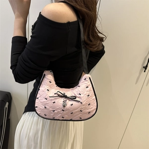 Borsa a spalla plissettata rosa con stampe di fiocchi neri e un grande fiocco