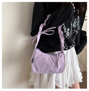 Detail of lavender crescent bag showing gathered strap and decorative bow knot