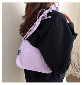 Detail of lavender crescent bag with ruffled shoulder strap and pleated fabric texture
