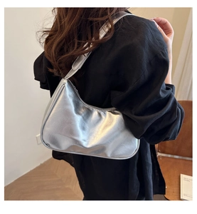 Close-up of silver hobo bag with metallic texture and sleek crescent shape design