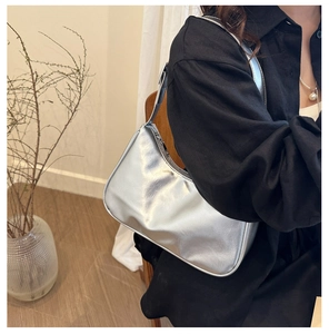 Borsa sottobraccio argento metallizzato su modella con forma a luna e finitura lucida