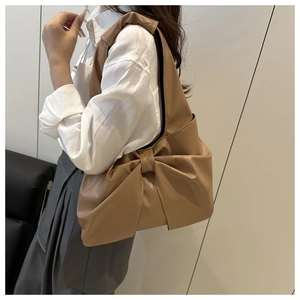 Detail shot of khaki PU leather shoulder bag featuring a large decorative ribbon bow