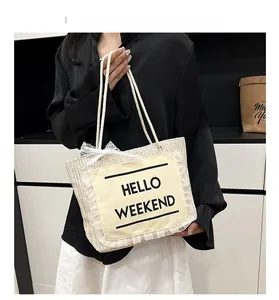 Detail of woven straw tote bag with HELLO WEEKEND canvas patch and white lace trim