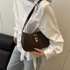 Retro dark brown underarm bag with gold metal buckle shown on model with white shirt