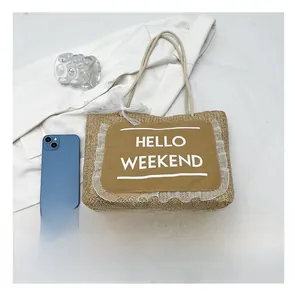 Straw tote bag with Hello Weekend lace patch shown next to a smartphone for size scale