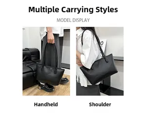 Model display of large black tote bag showing handheld and shoulder carrying styles