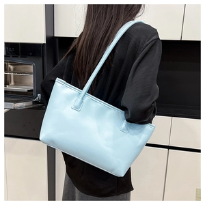 Light blue large capacity tote bag shown on shoulder against a minimalist interior