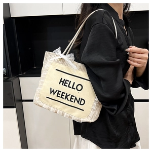 Close-up of straw tote bag with HELLO WEEKEND canvas pocket and delicate lace edge