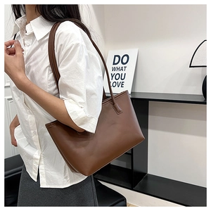 Detail of soft brown leather tote bag with fine texture and slim double shoulder straps