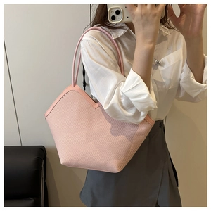 Detail of pink woven tote bag with V-shaped opening and slim shoulder strap