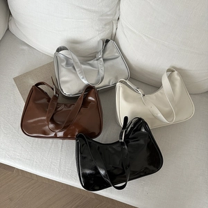 Hobo bags in metallic silver, brown, cream, and black on a sofa in a multi-color display