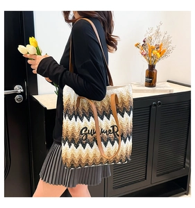 Close-up of rainbow straw tote bag with black SUMMER embroidery and leather straps