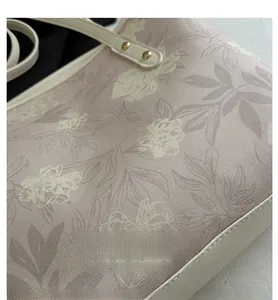 Close-up of floral tote bag fabric with golden rivets and Romantic Time text detail