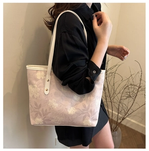 Detail of lavender floral tote bag with cream leather straps and gold rivets