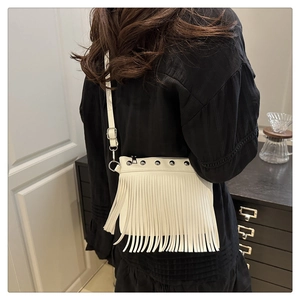 Détail du sac à bandoulière blanc à franges bohèmes avec œillets et clous argentés