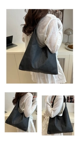 Detail view of large black matte tote bag showing fine stitching and spacious interior