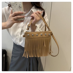 Detail of khaki leather crossbody bag with silver studs and bohemian tassel fringe