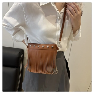 Detailed close-up of brown PU leather crossbody bag with fringe and silver stud rivets