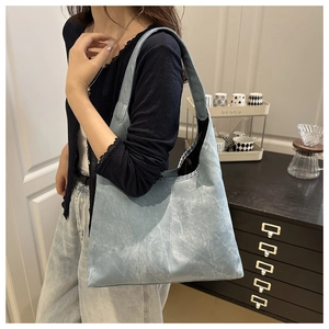 Detail view of large light blue hobo bag with unique marble texture and wide strap