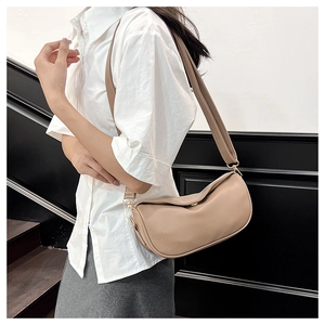 Macro detail of the light brown crescent bag showing high-quality pebble grain leather texture