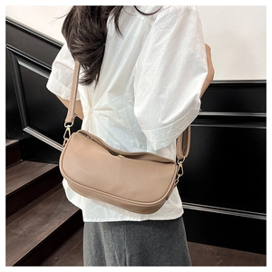 Khaki dumpling crossbody bag with adjustable wide strap shown on model's shoulder