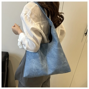 Detail view of light blue denim tote bag showing its large capacity and soft washed texture