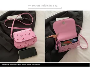 Detailed interior of pink cherry print crossbody bag showing capacity and magnetic closure