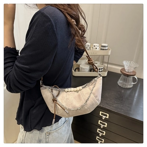 Détail du sac hobo beige avec chaînes argentées, perles blanches et bandoulière cuir