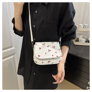 Detail of white PU shoulder bag with red cherry print and slender shoulder strap