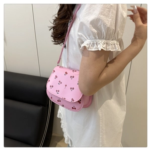 Detail of pink PU crossbody bag with red cherry prints and matching shoulder strap