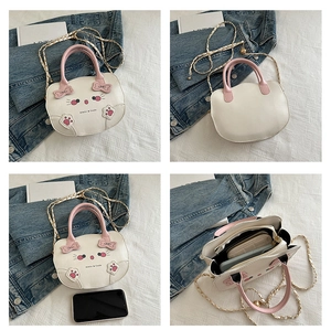 Vista detallada del bolso bandolera gato blanco con detalles rosa y compartimentos