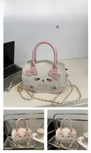 Detalle de bolso de gato blanco y rosa con orejas 3D, lazo y correa de cadena dorada