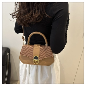 Detail of a beige contrast-texture box bag with woven flap and gold vintage clasp