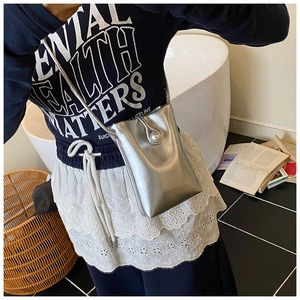 Vue détaillée du mini sac bandoulière argenté avec fermoir perle et fine bandoulière