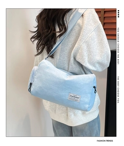 Detail of light blue canvas bucket bag showing fabric texture and brand label