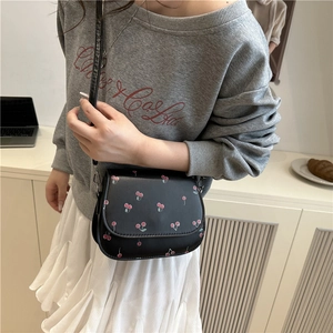 French chic black shoulder bag with cherry print shown on model for a trendy casual look