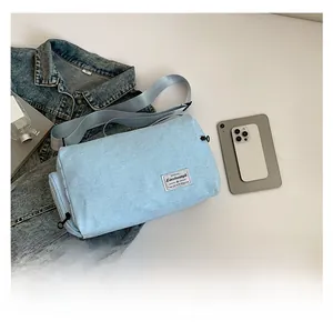 Detailed view of light blue canvas crossbody bag with drawstring and shoulder strap